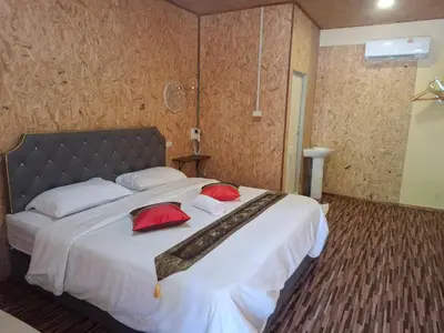 a bedroom with a large bed with red pillows on it at Fadel Residence in Ko Yao Yai