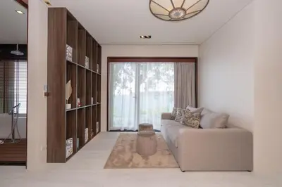 a living room with a couch and a large window at 33 - The Cove in Laem Singh Beach in Surin Beach
