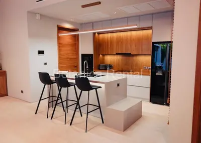 a kitchen with a island with bar stools at Villa M18 in Ban Pak Lak