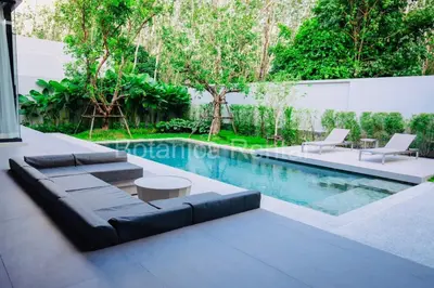 a swimming pool with a couch and a table at Villa M18 in Ban Pak Lak