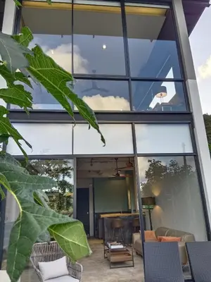 a house with large glass windows and a patio at Sky Lofts Airport Phuket in Nai Yang Beach