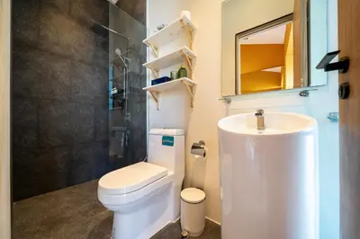 a bathroom with a white toilet and a sink at Luxury KING 3 BR, Gym, Sauna, BBQ, AirCon, 8 min Beach, Tennis Court, Boating Ave in Ban Pak Lak