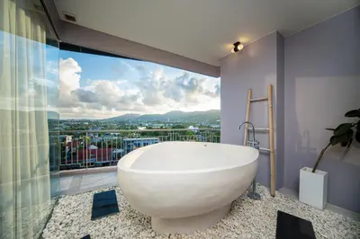a bath tub in a bathroom with a large window at The Blue Hotel in Chalong