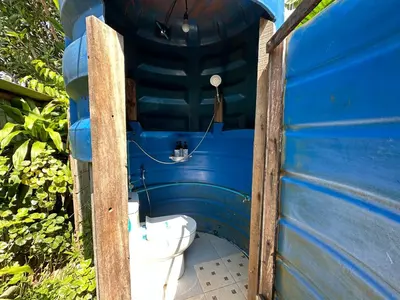 a toilet in the side of a blue building at Cashew Garden House in Chalong