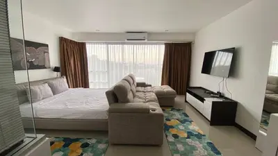 a bedroom with a bed and a couch and a television at Sea view studio Chic Condo Karon in Karon Beach