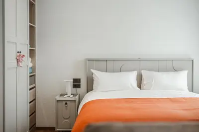 a bed with an orange blanket and white pillows at Квартира в The Title Halo 1 in Nai Yang Beach