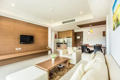 a living room with a white couch and a tv at Bangtao Tropical Residence Resort and Spa in Surin Beach