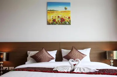 two swans sitting on a bed in a hotel room at Bangtao Tropical Residence Resort and Spa in Surin Beach