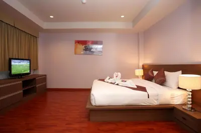a hotel room with a bed and a television at Bangtao Tropical Residence Resort and Spa in Surin Beach