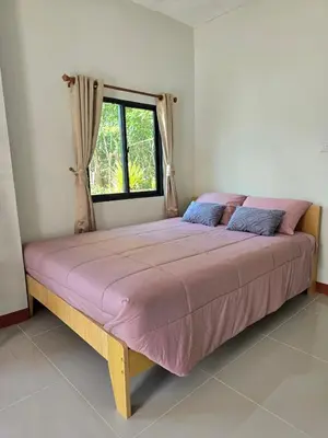 a large bed in a room with a window at Aonang Riverside Home in Ban Khlong Son