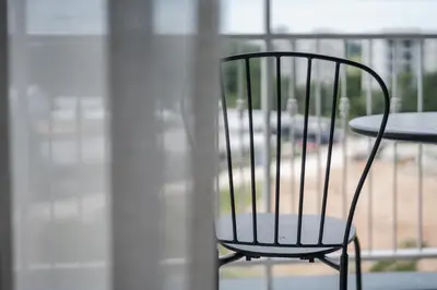a black chair sitting next to a table on a balcony at Квартира в The Title Halo 1 in Nai Yang Beach