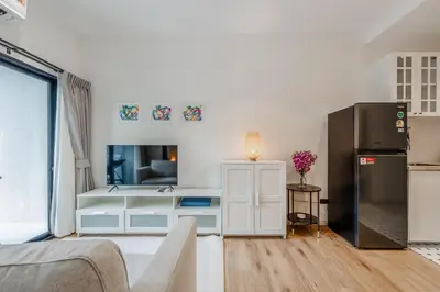 a living room with a couch and a refrigerator at Квартира в The Title Halo 1 in Nai Yang Beach