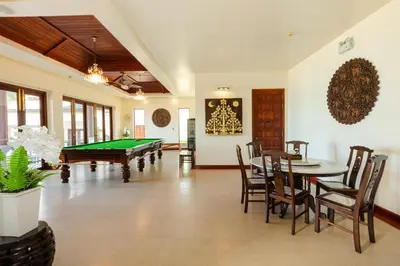 a living room with a pool table and a dining room at Grand View Panwa Luxury Villa in Ban Ao Makham