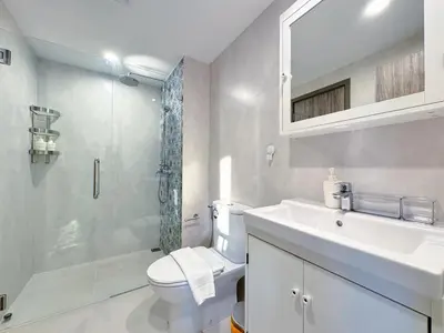 a bathroom with a toilet and a shower and a sink at Digital Nomad Home Away With Pool & Gym in Nai Yang Beach