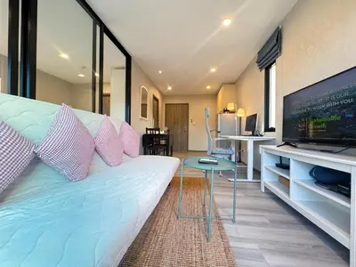 a living room with a couch and a flat screen tv at Digital Nomad Home Away With Pool & Gym in Nai Yang Beach