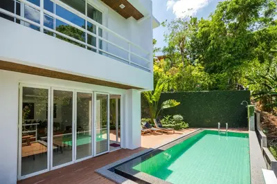 a swimming pool in front of a house at Jirana Patong in Patong Beach