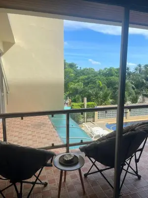 a balcony with two chairs and a view of a pool at Family place in Ban Saiyuan (1)
