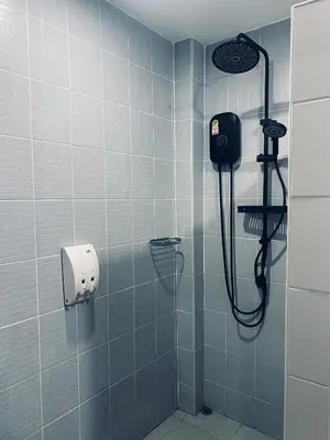 a bathroom with a shower with a phone on the wall at Гостевой домик in Ban Saiyuan (1)