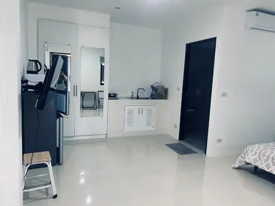 a kitchen with a black refrigerator and white walls at Гостевой домик in Ban Saiyuan (1)