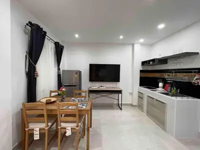 a living room with a table and a kitchen at Charming Villa Suite with Cozy Terrace near Beach in Patong Beach