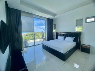 a bedroom with a bed and a large window at The View Condominium 360 m2 Sea View Penthouse in Kata Beach