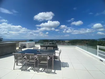 a patio with a table and chairs on a roof at The View Condominium 360 m2 Sea View Penthouse in Kata Beach