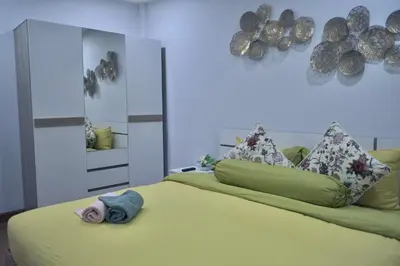 a bedroom with a yellow bed with a mirror at MODERN 3BR Katabeach sweet Home in Kata Beach