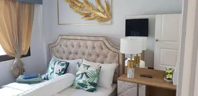 a bedroom with a bed with pillows and a table at MODERN 3BR Katabeach sweet Home in Kata Beach