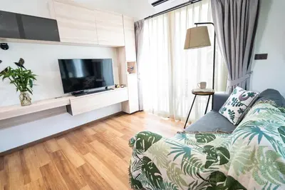 a living room with a couch and a flat screen tv at Paradise Bird in Nai Yang Beach