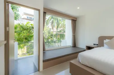 a bedroom with a bed and a large window at Sunnyside Kata in Kata Beach