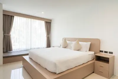 a bedroom with a white bed and a window at Sunnyside Kata in Kata Beach