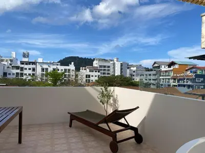 a balcony with a bench and a view of a city at Sea Breeze Villa Patong in Patong Beach