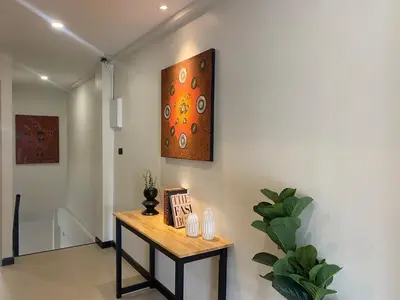 a room with a table and a painting on the wall at Sea Breeze Villa Patong in Patong Beach