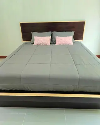 a large bed with two pink pillows on it at Aonang Riverside Home in Ban Khlong Son