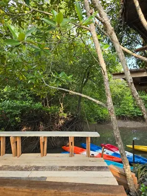 a bench sitting on a dock next to a boat at Aonang Riverside Home in Ban Khlong Son
