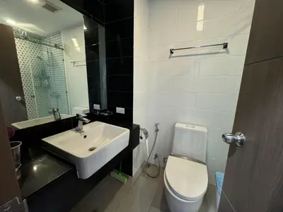 a bathroom with a white toilet and a sink at Royal Lee Condo in Ban Bo Han