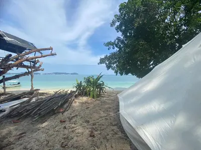 a tent on the beach with the ocean in the background at Naturist Beach Camping Private Beach Phuket in Ko Lone