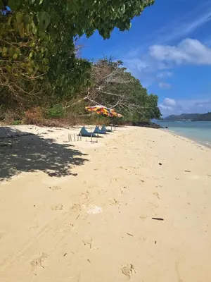 two beach umbrellas and chairs on a beach at Naturist Beach Camping Private Beach Phuket in Ko Lone