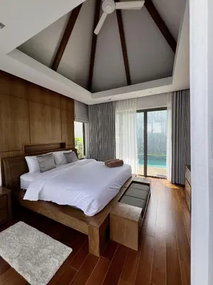 a bedroom with a large bed and a large window at Bang Tao Anchan Flora 3 bd in Ban Phru Champa