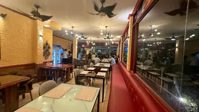 a restaurant with tables and people sitting at tables at Taj Palace Patong Beach in Patong Beach