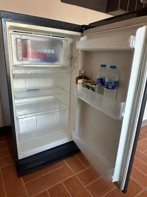 an open refrigerator with bottles of water in it at Taj Palace Patong Beach in Patong Beach