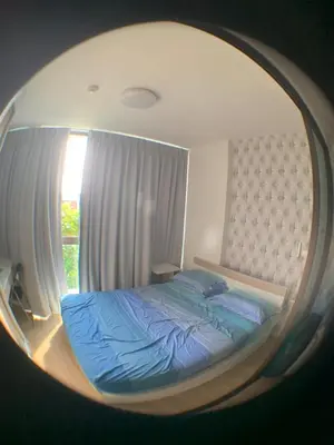 a bedroom with a bed in a round mirror at Beautiful space in Ban Sam Kong