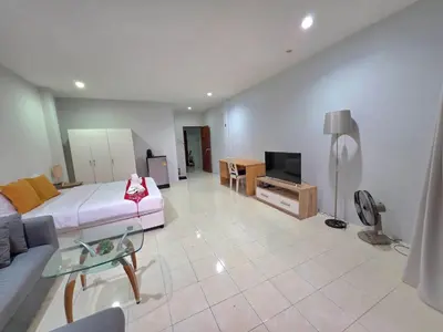 a large living room with a bed and a tv at Sunshine Guesthouse Nanai Patong in Patong Beach