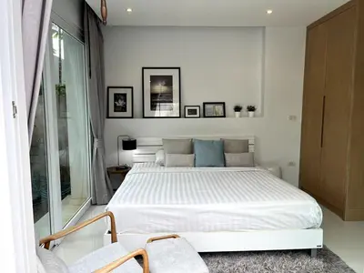 a white bedroom with a bed and two chairs at Skylight Nice Pool Villa in Kamala in Kamala Beach