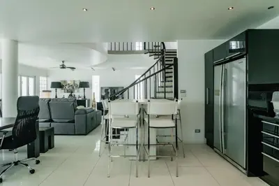 a living room with a glass table and chairs at Skyfall Private Pool Villa In Rawai in Rawai Beach