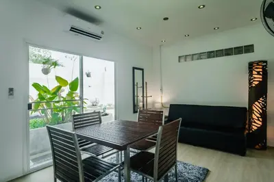 a dining room with a table and chairs and a couch at Skyfall Private Pool Villa In Rawai in Rawai Beach