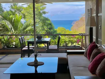 a living room with a couch and a view of the ocean at Kata Seaview Serenity - Luxury 1BR Apartment in Karon Beach