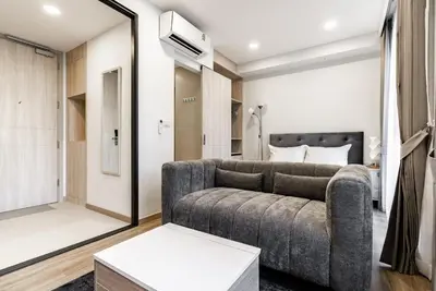a living room with a couch and a bedroom at Skypark by Villacarte in Laguna Phuket