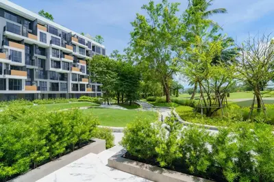 an apartment building with a garden in front of it at Skypark by Villacarte in Laguna Phuket