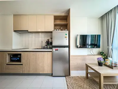 a kitchen with a stainless steel refrigerator and a table at New 1BDR Fantasea Kamala beach in Kamala Beach